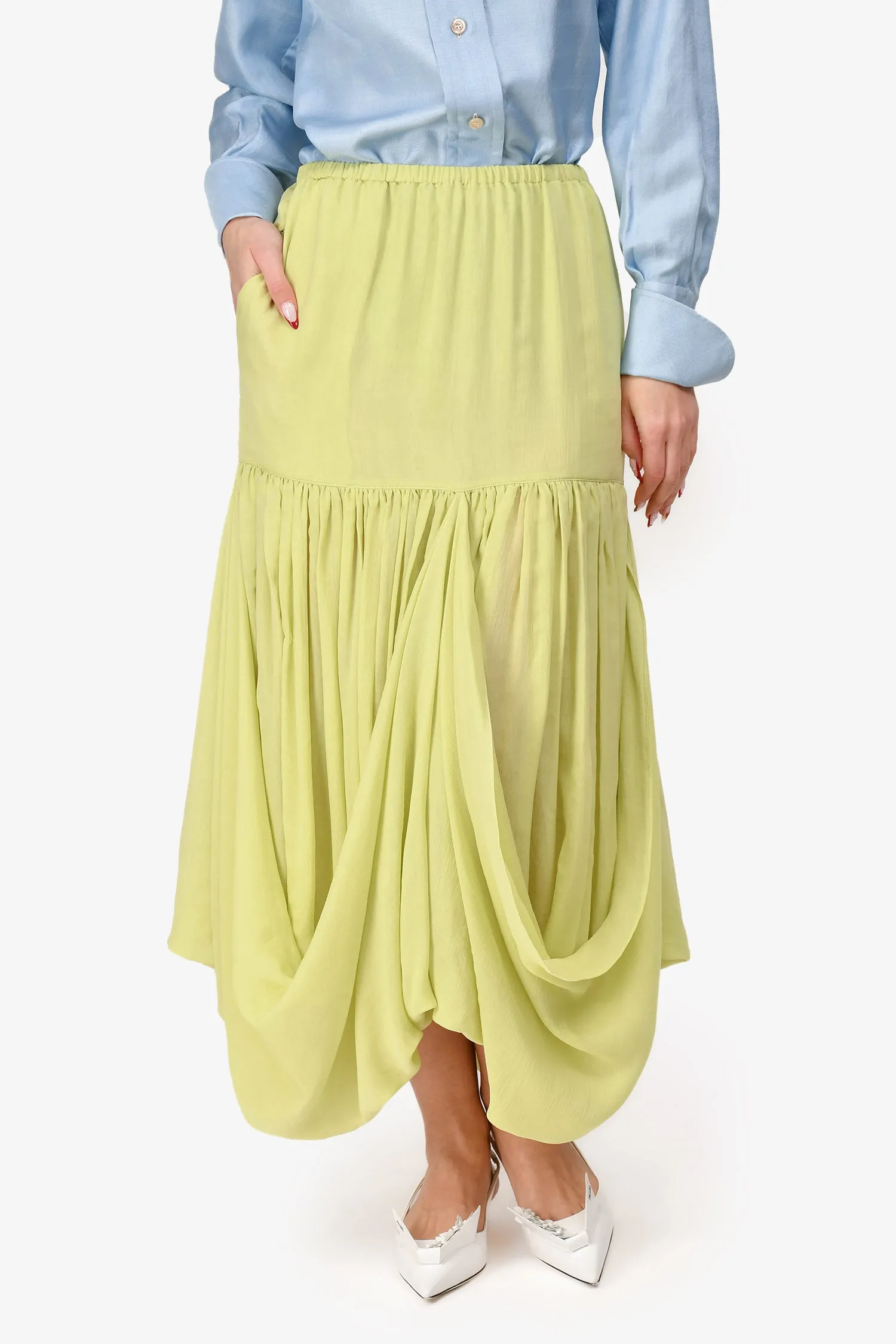 La jupe mi-longue The Row en soie vert pistache à volants taille S