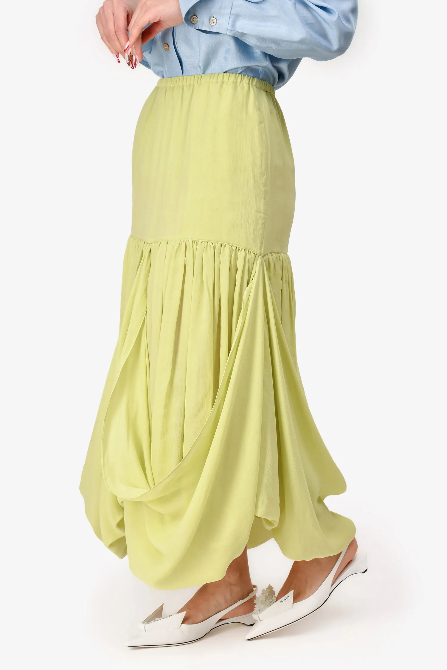 La jupe mi-longue The Row en soie vert pistache à volants taille S